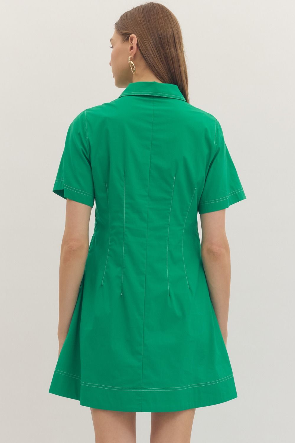 Solid short sleeve mini dress featuring stitch detail at front placket. Hidden button closure at front. Side pockets. Lined. Woven. Non-sheer. Lightweight.