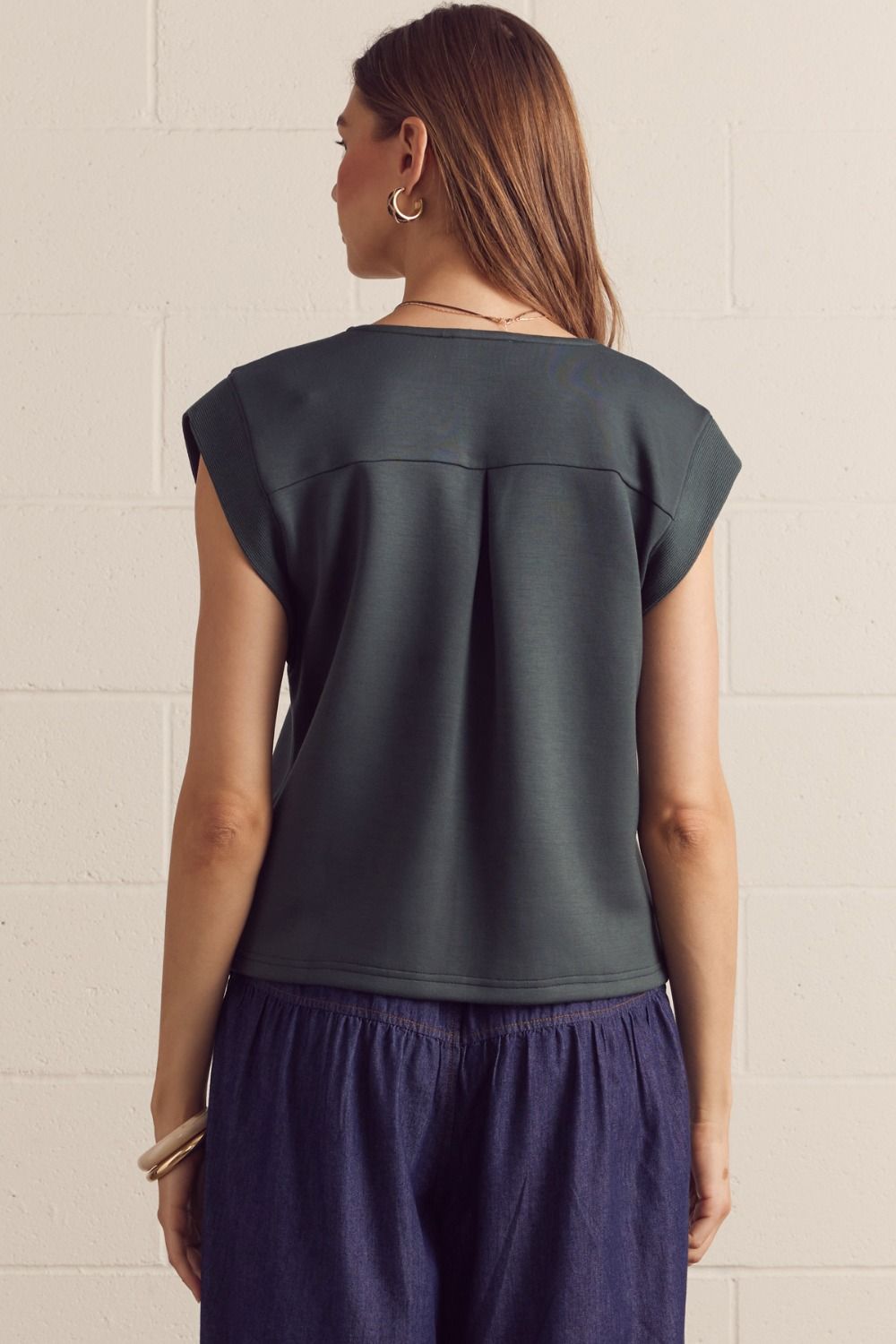 Solid cap sleeve top featuring center front seam detail. V-neck. Back yoke with center pleat. Knit. Unlined. Non-sheer. Lightweight.