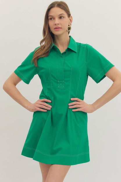 Solid short sleeve mini dress featuring stitch detail at front placket. Hidden button closure at front. Side pockets. Lined. Woven. Non-sheer. Lightweight.