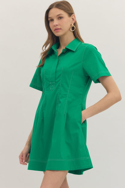 Solid short sleeve mini dress featuring stitch detail at front placket. Hidden button closure at front. Side pockets. Lined. Woven. Non-sheer. Lightweight.